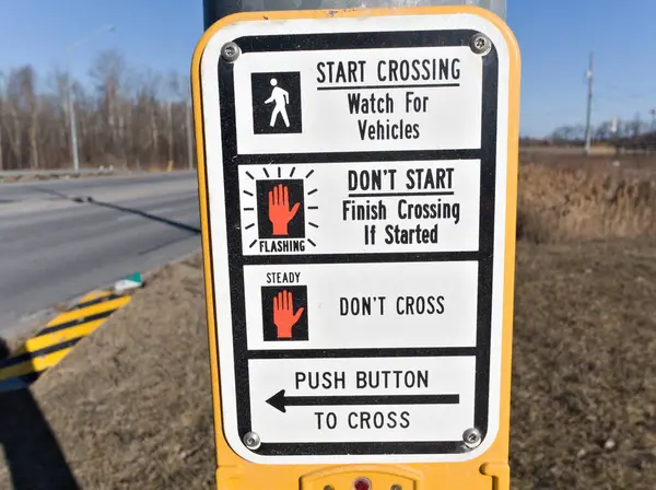 Görüntü, yolu ne zaman geçmenin güvenli olduğunu açıklayan yaya talimatı işaretini gösteriyor. Beyaz yürüyen bir figür, karşıya geçmekte sorun olmadığı anlamına gelir. Kırmızı bir el, geçişi bitirmek için yanıp sönen bir işaret verir.