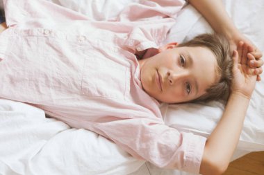 Çocuk yerde oturuyor ve kameraya bakıyor, yaz zamanı.