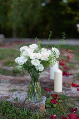 Bahçedeki bir vazoda beyaz çiçekler ve kırmızı güller. yüksek kaliteli fotoğraf