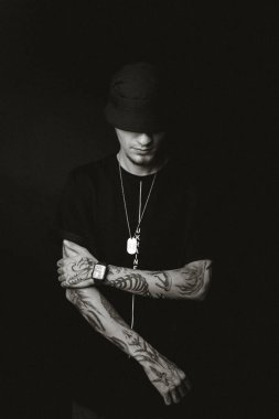 Siyah şapkalı dövmeli adam.