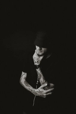 Siyah şapkalı dövmeli adam.