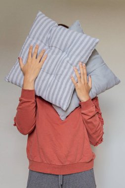 İki yastıklı genç bir kadının kırpılmış görüntüsü.