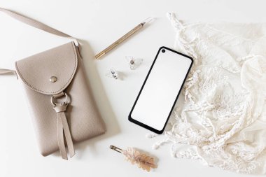 Cep telefonlu güzellik kolajı ve beyaz arka planda aksesuarlar. Düz yatış, üst görünüm. 
