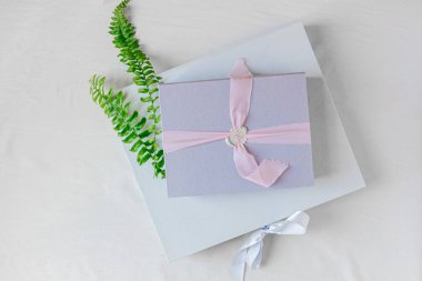 Beyaz arkaplanda hediye kutuları ve eğrelti otu yaprakları