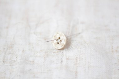 Kompozisyon dikiyorum. Bej arkaplanda bej düğmeler.