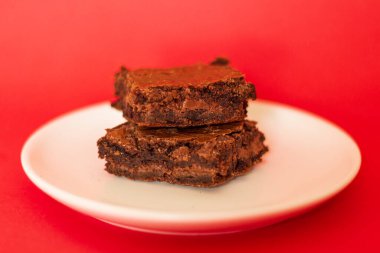 Kırmızı arka planda Brownie. Modern yemek tasarım kompozisyonu