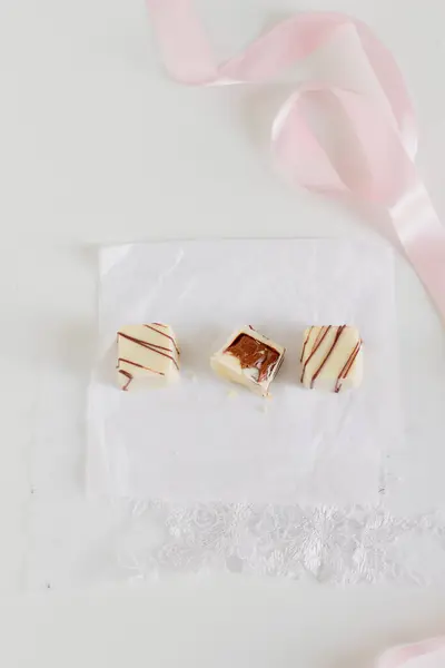 Lahodné Bílé Čokoládové Bonbóny Světle Růžová Stuha Bílém Pozadí — Stock fotografie