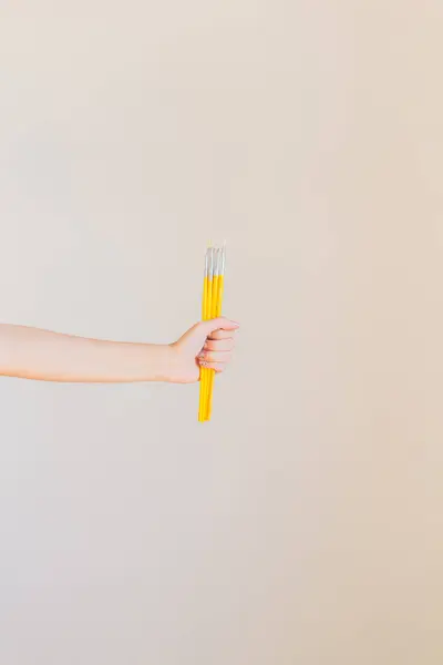 Kobieta Trzyma Garść Żółtych Pędzli — Zdjęcie stockowe