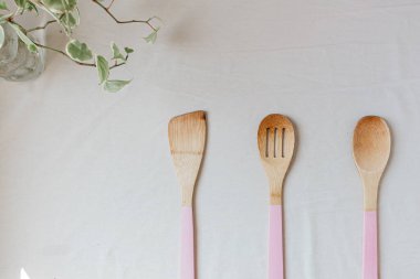 Beyaz arka planda yeşil bitkili mutfak aletlerinin üst görüntüsü. Yemek pişirme konsepti. 