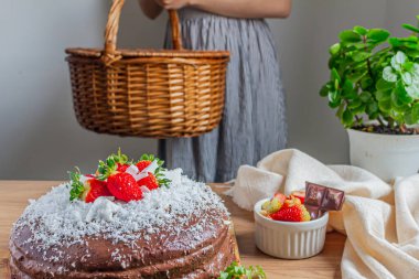 Arkaplanda çikolata, hindistan cevizi ve çilekli pasta var..