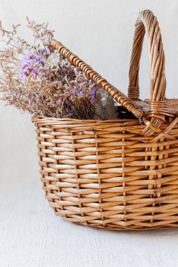 Piknik sepetinin içinde kurumuş çiçekler var.