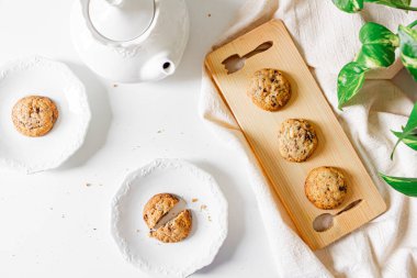 İki konsept için kahvaltı. Kesme tahtasındaki kurabiyeler, çaydanlık, iki tabak kurabiye, keten kumaş, boa yaprakları.. 