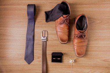 Erkek zarif aksesuarları. Ahşap arka planda kahverengi ayakkabılar. Düğün konsepti hazırlığı.