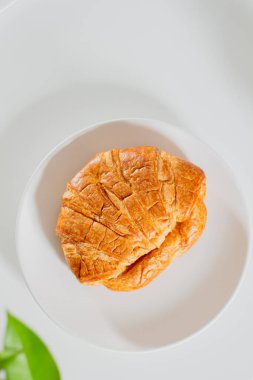 Sabah kahvaltısı beyaz tabakta kruvasanla.