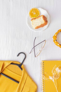 Bilgisayarlı ofis masası çerçevesi, turuncu pasta, hırka, gözlük ve beyaz arka planda planlayıcı.. 