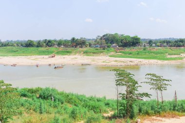 Amazon Mahallesi Peyzajı. Ahşap evler, kanolar, nehir ve palmiye ağaçları..