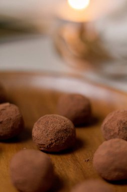 Lezzetli tatlı konsepti. Tahta tabakta kakao tozuyla kaplı çikolatalı trüf mantarlarının yakın görüntüsü.. 