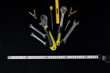 Siyah arka planda bakım ve inşaat araçları.