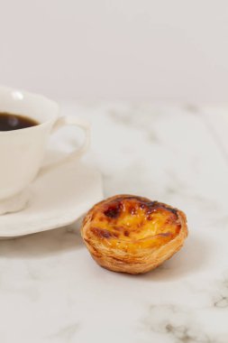 Nata Pastel. Yemek tasarımı. Estetik kompozisyon. Yumurtalı tartlı tatlı ile bir fincan kahve.