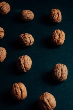 Koyu arkaplanda çiğ ceviz yığını.