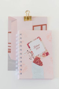 Beyaz arkaplanda pembe not defterleri olan kadınsı kompozisyon. 