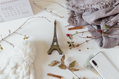 Beyaz arka planda kadın kış aksesuarları. Ilık beyaz örgü şapka ve gri eşarp. Düz yatış, üst görünüm. 