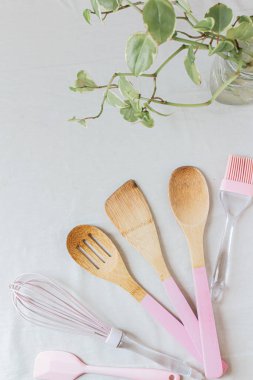 Beyaz arka planda açık pembe mutfak aletleri. Kadın mutfağı. Yemek pişirme konsepti. 