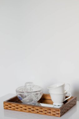 Ayna tepsisinde şeffaf kâsesi olan iki beyaz bardak.