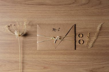 Nikah davetiyesi, alyanslar, kuru çiçekler ve yapraklar. 