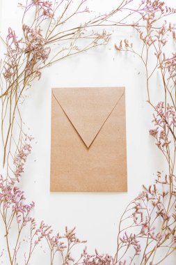 Yuvarlak çerçeve, leylak çiçekleri ve el işi kağıt zarfları. Düz yatış, üst görünüm. 