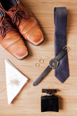 Erkek zarif aksesuarları. Ahşap arka planda kahverengi ayakkabılar. Düğün konsepti hazırlığı.