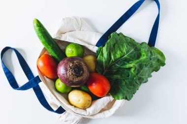Beyaz arka planda sebzeli saman sepeti. Düz konum, üst görünüm, kopyalama alanı.