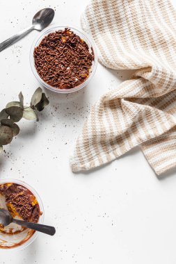 Havuç ve çikolatalı kek, mutfak havlusu ve okaliptüs yapraklı beyaz.