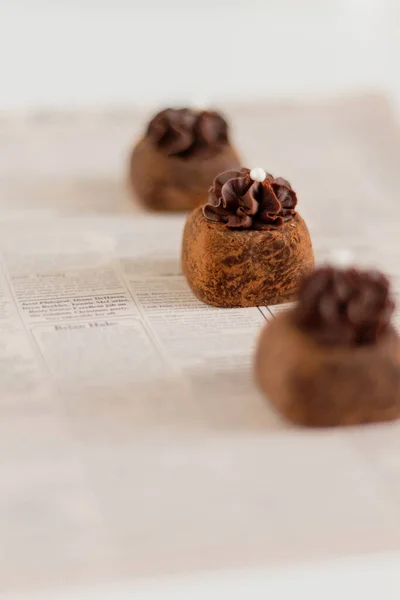 Tres Caramelos Chocolate Fondo Del Periódico Estilo Comida —  Fotos de Stock