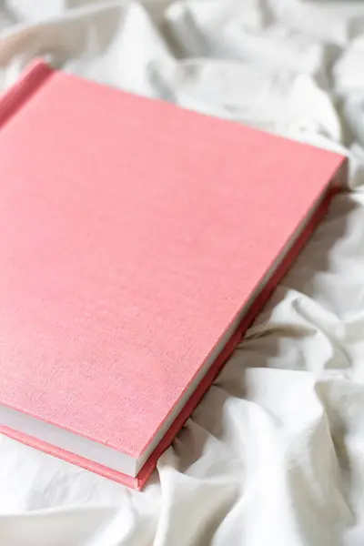 白色床单上的粉色相册 — 图库照片