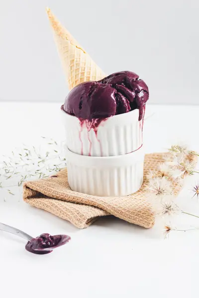 Waffle cone with acai ice cream in bowls on white background. floral background. Brazilian spring, summer concept.