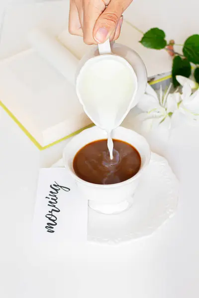コーヒーカップにミルクを注ぐ女性の手 — ストック写真