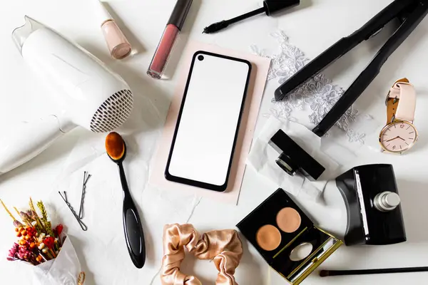 Beauty collage with cosmetics and mobile phone on white background.