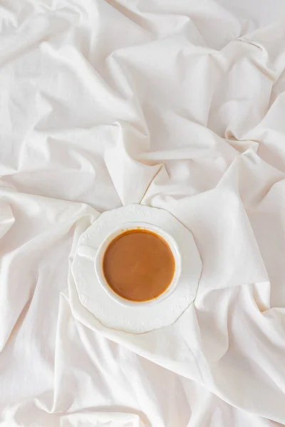 在凌乱的床上俯瞰着一杯加牛奶的咖啡 早餐作文 — 图库照片