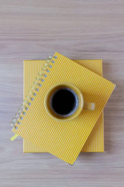 在木制桌子上黄色规划者顶部的咖啡杯的顶部视图 — 图库照片