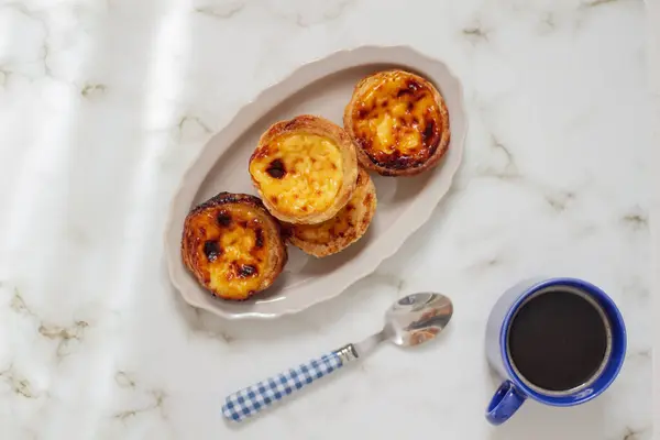 Nata Pastel. Food styling. Aesthetic composition.  Portuguese egg tarts on white plate