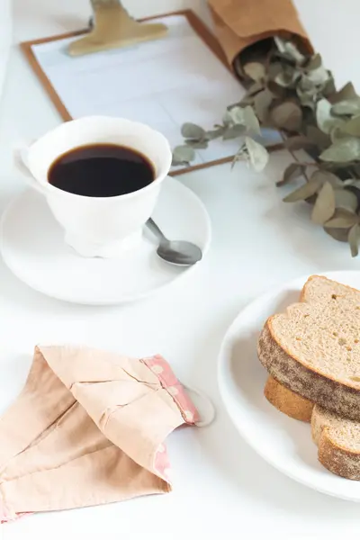 一杯咖啡 一堆桉树叶 面包和面具在白桌上 关于大流行病概念的咖啡馆 — 图库照片