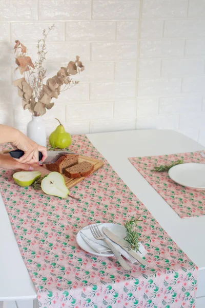 Female hand cutting nut cake for breakfast on cutting board