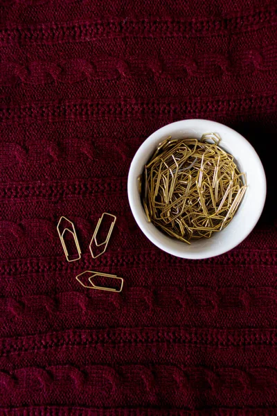 Golden Paper Clips Dark Red Sweater Texture Background Flat Lay — Stock Photo, Image