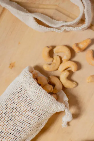 Cashew nuts on cotton bag. Beige composition.