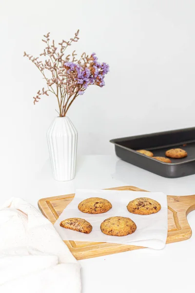 木製カッティングボードの自家製クッキーと白い背景にミルクのグラス — ストック写真
