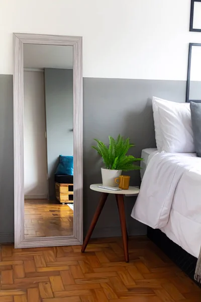 stock image Comfortable home interior. Bed reflection in the mirror with green houseplants.  