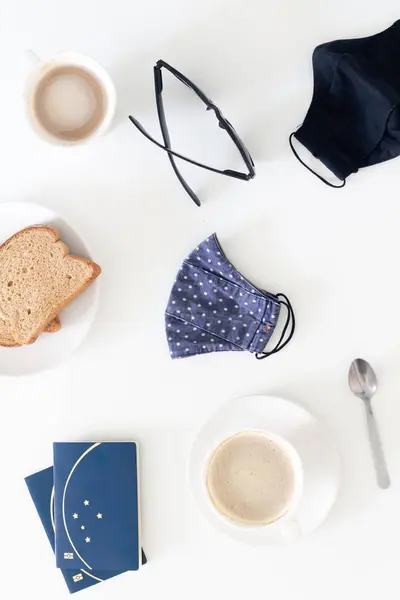 旅途中 在白桌上放上咖啡和面罩 享用早餐 关于流行病概念的旅行 咖啡馆 — 图库照片