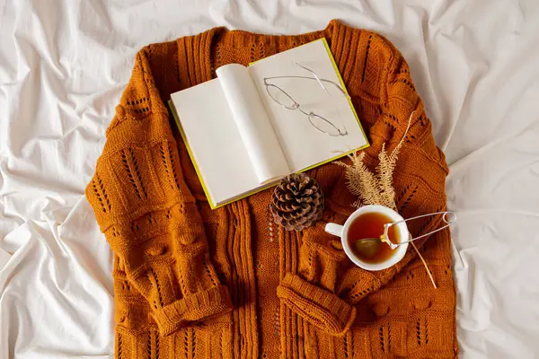 女性ファッションコンポジション 暖かい女性は編まれたセーター 白いベッドのシートの背景にお茶を編みました 秋の作曲について — ストック写真