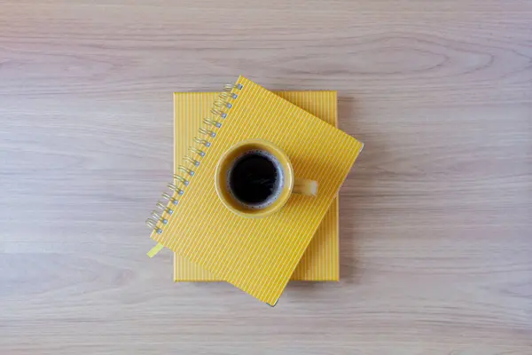 在木制桌子上黄色规划者顶部的咖啡杯的顶部视图 — 图库照片